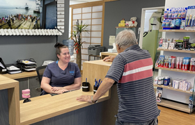 A Man Talking To A Person Behind The Desk— Trower Dental Dentists in Casuarina, NT